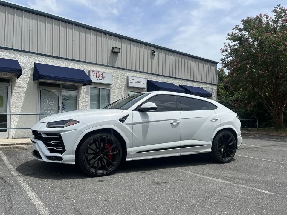 White Lamborghini Urus outside 704Tint with an illustrative window tint overlay